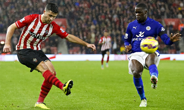 Southampton's Shane Long fires a shot on goal despite the attention of Leicester defender Wes Morgan